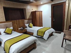 a hotel room with two beds and a chair at The Himalayan Majesty Hotel in Chopta
