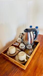a tray with a tea kettle and dishes on a table at Sari Bungalow in Ubud