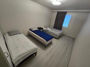 a small room with two beds and a window at Mudita Apartment in Mikkeli