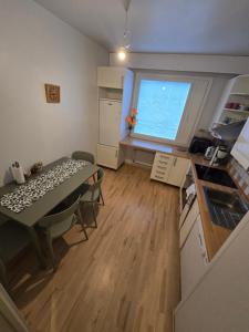 a small kitchen with a table and a large window at Mudita Apartment in Mikkeli