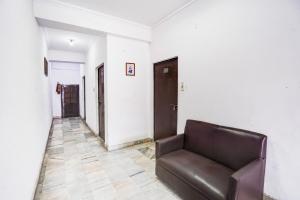 a leather couch in a room with a hallway at Super Hotel O Tyagi Road Near Prince Chowk Formerly Hotel Prabhu in Dehradun +38 photos