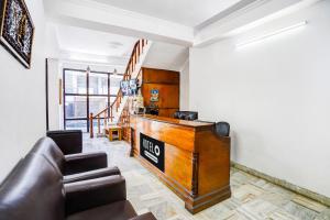 a living room with a couch and a podium at Super Hotel O Tyagi Road Near Prince Chowk Formerly Hotel Prabhu in Dehradun