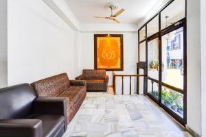 a living room with a couch and a chair at Super Hotel O Tyagi Road Near Prince Chowk Formerly Hotel Prabhu in Dehradun