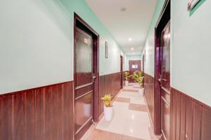 a hallway with wooden doors and potted plants at Collection O Rispana Pul Dehradun Formerly Hotel Square 1 in Clement Town