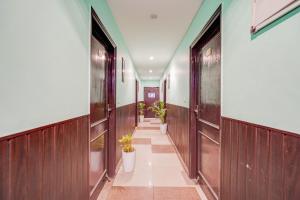 a hallway with wooden doors and potted plants at Collection O Rispana Pul Dehradun Formerly Hotel Square 1 in Clement Town
