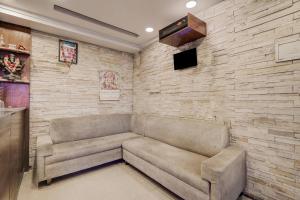a living room with a couch and a brick wall at Collection O Rispana Pul Dehradun Formerly Hotel Square 1 in Clement Town +38 photos