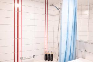 a shower with a blue shower curtain in a bathroom at Central12 Apartment - Free Parking in Thun +18 photos
