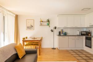 a living room with a couch and a kitchen at Central12 Apartment - Free Parking in Thun