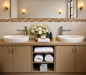 a bathroom with two sinks and a vase of flowers at Balingup Highview Chalets in Balingup +54 photos