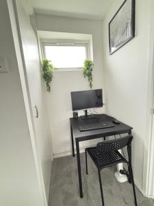 a desk with a computer and a chair in a room at Cosy one bed Flat in Stevenage in Stevenage