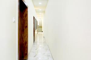 a hallway with white walls and marble floors at Townhouse Govardhan in Govardhan