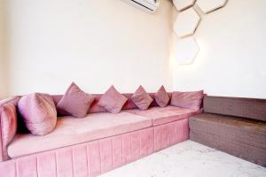 a pink couch in a room with pillows on it at Townhouse Govardhan in Govardhan