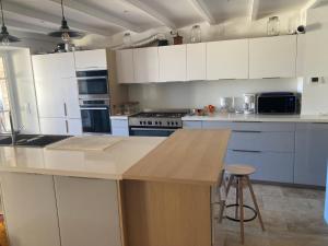 a kitchen with white cabinets and a counter top at Oasis de Compostelle in Lauzerte