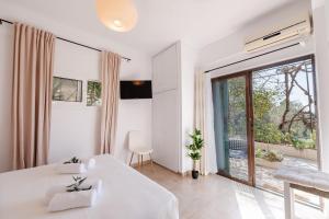 a white room with a bed and a large window at The 7 Trees Apartments by Konnect, Nisaki in Nisaki