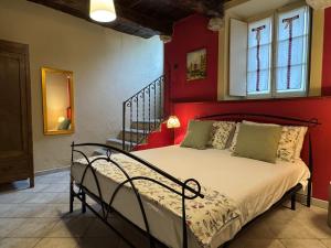 a bedroom with a bed with a red wall at Il Torchio - Guest House Lago Maggiore in Dormelletto