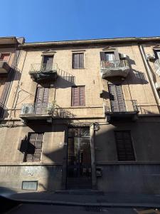 a tall building with balconies and a door on it at Etna Vibes Home in Catania