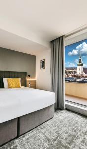 a bedroom with a large bed and a large window at Hotel International Brno in Brno