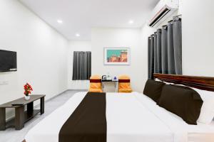 a bedroom with a bed and a table and chairs at Super Collection O Vanasthalipuram in Hyderabad