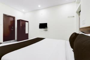 a white room with two doors and a tv at Super Collection O Vanasthalipuram in Hyderabad