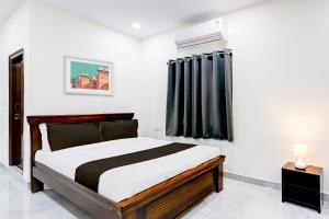 a bedroom with a bed and a black curtain at Super Collection O Vanasthalipuram in Hyderabad