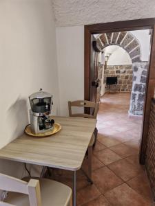 a table with a coffee maker sitting on top of it at Gli Ulivi del Nonno - Casale immerso nel verde a pochi chilometri dalla Reggia - in Caserta