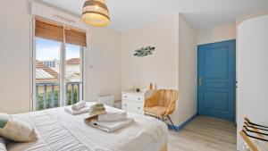 a bedroom with a bed with a blue door and a window at Bel Apt neuf - HyperCentre 400m Plage-Pkg-Wifi-T3 in Arcachon
