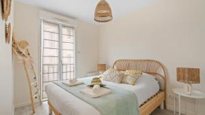 a bedroom with a bed with towels on it at Bel Apt neuf - HyperCentre 400m Plage-Pkg-Wifi-T3 in Arcachon