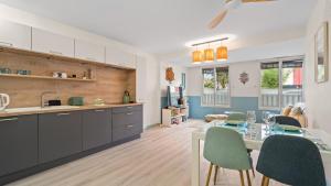 a kitchen and dining room with a table and chairs at Bel Apt neuf - HyperCentre 400m Plage-Pkg-Wifi-T3 in Arcachon