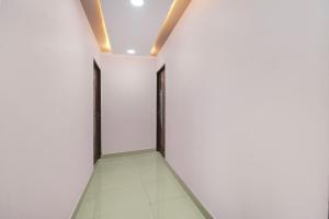 an empty corridor with two doors in a white wall at Hotel O Lakdikapul Near Birla Mandir in Hyderabad