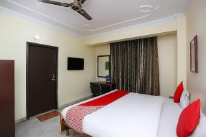 a bedroom with a white bed and red pillows at The Zen Stays Patna in Patna