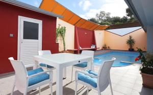 a patio with a table and chairs and a swimming pool at The Bordeaux Door in Egina