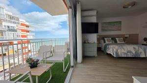 a bedroom with a bed and a balcony with the ocean at Las Brisas in Benicàssim
