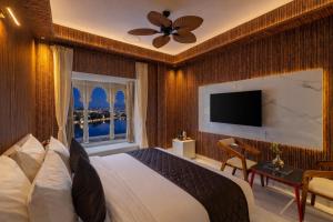 a bedroom with a large bed and a window at Shakuntalam Sagar - Luxury Boutique Lake View Hotel, Udaipur in Udaipur