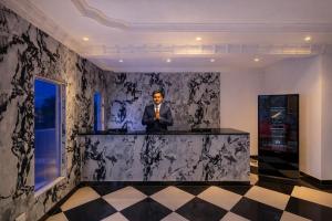 a man standing at a bar in a room at Shakuntalam Sagar - Luxury Boutique Lake View Hotel, Udaipur in Udaipur