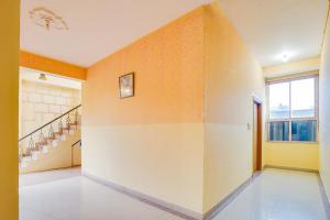 a hallway with orange and white walls and stairs at Super Hotel O JLN Marg Malviya Nagar Formerly Hotel Braj Haveli in Jaipur