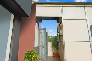 an open door of a house with a plant at Super Hotel O JLN Marg Malviya Nagar Formerly Hotel Braj Haveli in Jaipur
