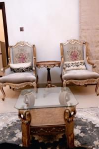 two chairs and a coffee table in a room at The Grandeur Suite 1 in Rawalpindi
