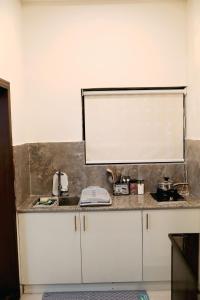 a kitchen counter with a sink and a mirror at The Grandeur Suite 1 in Rawalpindi