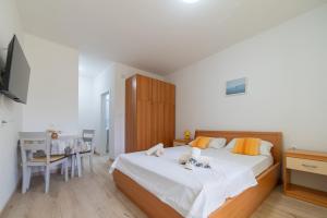 a bedroom with a bed and a desk and a table at Nikola studio in Božava