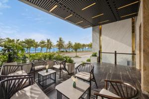 a patio with tables and chairs and the ocean at DAO NGOC BEACH HOTEL Da Nang in Danang +80 photos