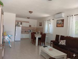 a living room and kitchen with a couch and a table at Vila Rogač in Tivat