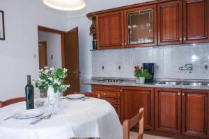 a kitchen with a table with a white table cloth at Apartments Suzy in Vantačići