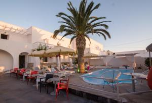 a resort with a palm tree and a swimming pool at Beach Boutique Hotel in Kamari