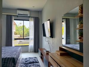 a bedroom with a mirror and a bed and a window at Tanner House Krabi in Ban Klang