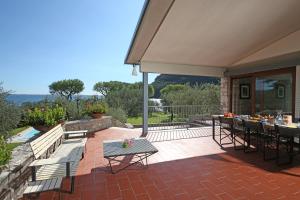 eine Terrasse mit einem Tisch und Stühlen auf einer Terrasse in der Unterkunft Villa Elena in Manerba del Garda