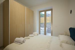 a bedroom with a large white bed with towels on it at Danys home in Ischia Town