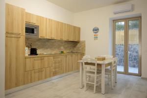 a kitchen with wooden cabinets and a table and chairs at Danys home in Ischia Town +26 photos