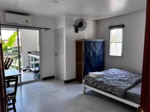 a bedroom with a bed and a table and a window at Ko Lipe Appartamenti in Ko Lipe