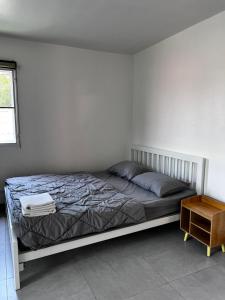 a white bedroom with a bed and a table at Ko Lipe Appartamenti in Ko Lipe