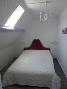 a bedroom with a bed with a window and a chandelier at Villa D'ALBATRE in Dieppe